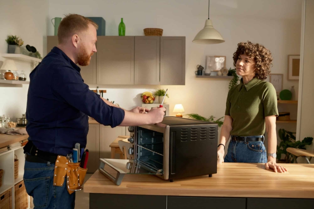 man repairing broken microwave at home e1736315849877