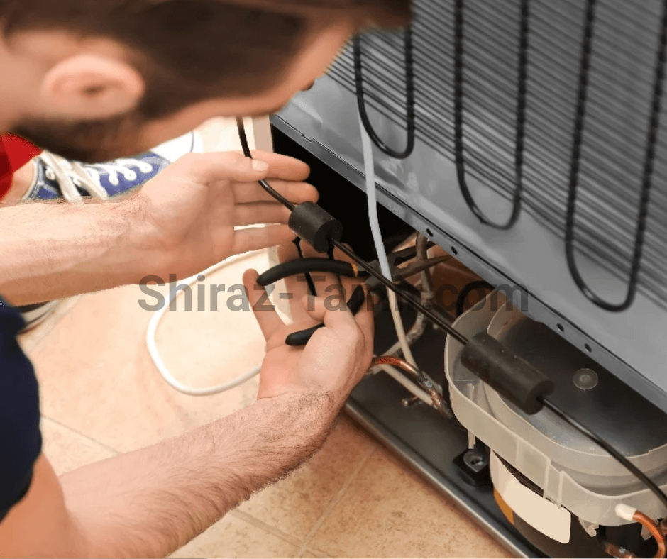 تعمیرکار یخچال در حال رفع مشکل گاز موتور یخچال